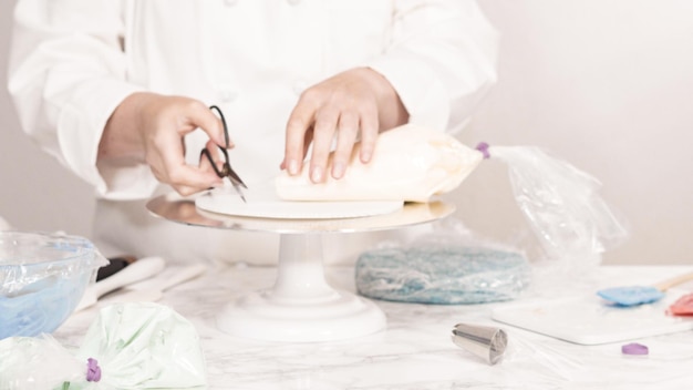 Pas à pas. Empilez les couches de gâteau pour créer le gâteau rond à la vanille à trois couches.