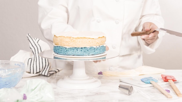 Pas à pas. Empilez les couches de gâteau pour créer le gâteau rond à la vanille à trois couches.