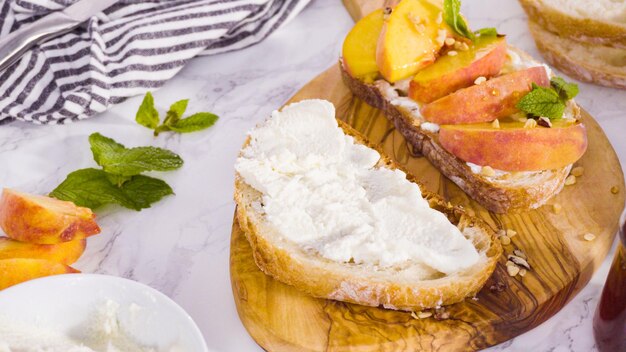 Pas à pas. Faire des toasts à la ricotta avec des pêches et des baies biologiques.