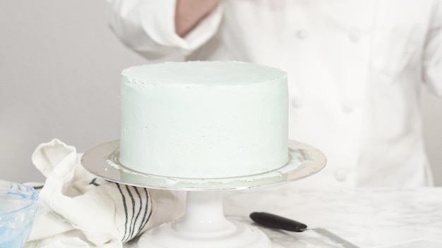 Pas à pas. Glaçage autour d'un gâteau à la vanille à trois couches avec glaçage à la crème au beurre.