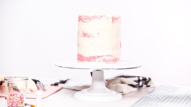 Photo pas à pas. glacer un grand gâteau d'anniversaire avec un glaçage à la crème au beurre blanc.