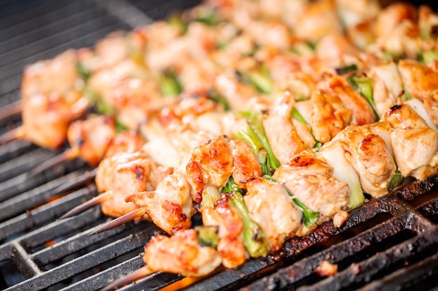 Pas à pas. Griller des yakitori de poulet sur des brochettes de bambou sur un gril à gaz extérieur.