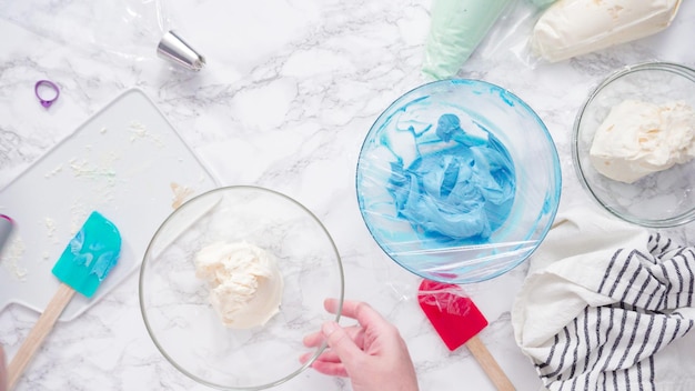 Pas à pas. Mélanger du colorant alimentaire avec du glaçage à la crème au beurre.