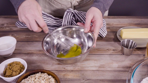 Pas à pas. Mélanger les ingrédients pour cuire des biscuits à l'avoine dans un bol en verre.