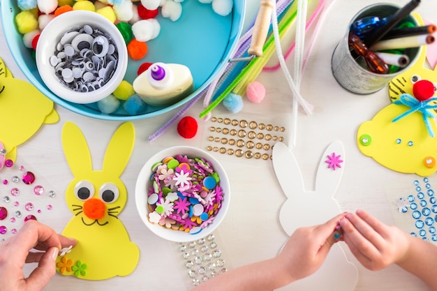 Pas à pas. Mère et fille décorant des lapins de Pâques.