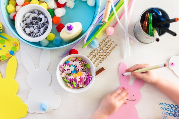 Pas à pas. Mère et fille décorant des lapins de Pâques.