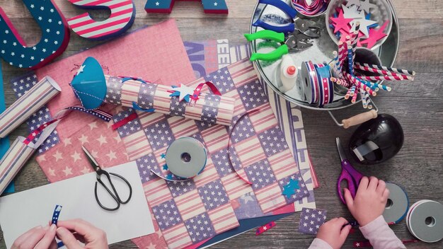 Pas à pas. Mère et fille fabriquant des pétards en papier pour la célébration du 4 juillet.