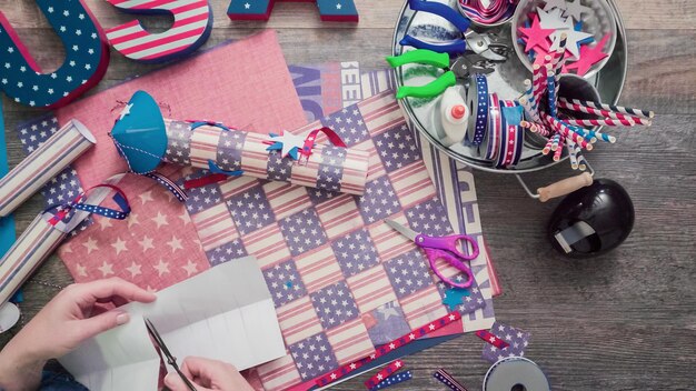 Pas à pas. Mère et fille fabriquant des pétards en papier pour la célébration du 4 juillet.