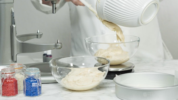 Pas à pas. Mesurer la pâte à gâteau avec une balance de cuisine numérique pour cuire un gâteau à la vanille à trois couches.