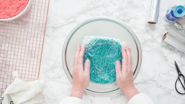 Pas à pas. Mise à plat. Envelopper les couches de gâteau fraîchement cuites dans un film alimentaire transparent et une feuille de cuisson pour les congeler.