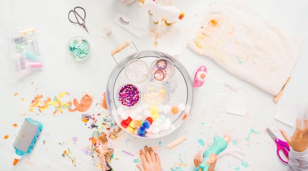 Pas à pas. Petites filles décorant une licorne en papier mâché avec des paillettes et des fleurs en papier.