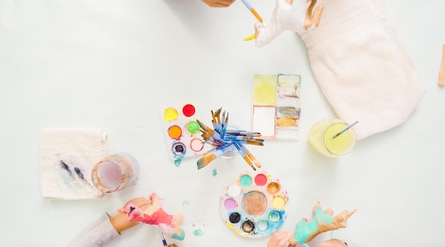 Pas à pas. Petites filles peignant une licorne en papier mâché avec de la peinture acrylique.