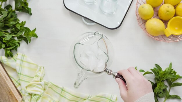 Pas à pas. Préparation de limonade traditionnelle avec des citrons frais tranchés et de la menthe.