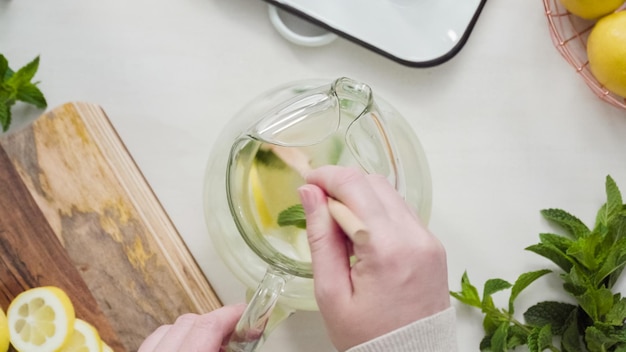 Pas à pas. Préparation de limonade traditionnelle avec des citrons frais tranchés et de la menthe.