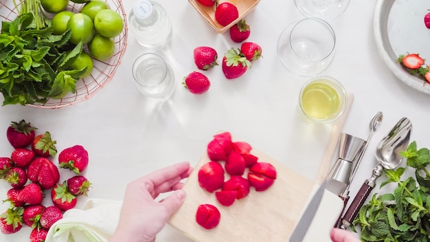 Pas à pas. Trancher des fruits pour mojito à la fraise à partir de fraises biologiques fraîches.