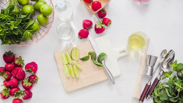 Pas à pas. Trancher des fruits pour mojito à la fraise à partir de fraises biologiques fraîches.