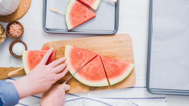 Pas à pas. Trancher la pastèque en wadges pour faire des sucettes glacées à la pastèque.