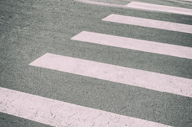 Passage piéton peint sur l'asphalte, détail d'un signal de circulation, informations sur le trafic pour les piétons et les conducteurs, sécurité dans le concept de jungle en béton