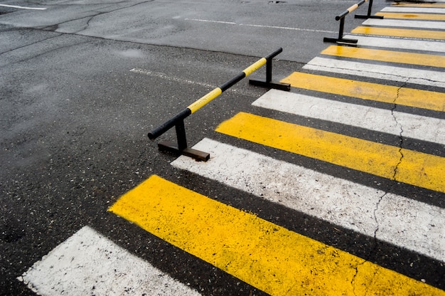 Passage pour piétons à proximité des parkings, bandes blanches et jaunes.