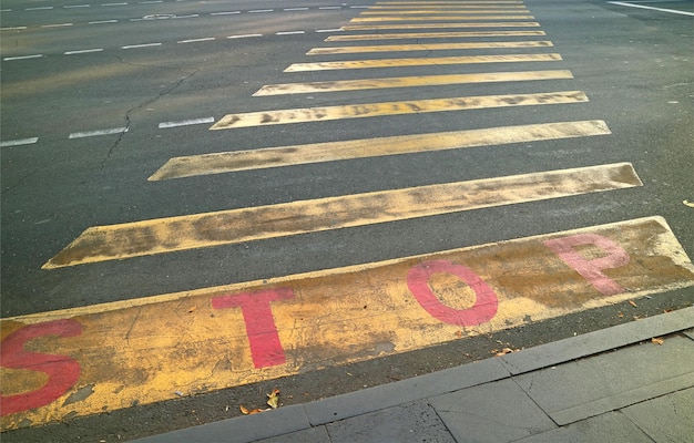 Passage pour piétons à rayures jaunes avec le mot STOP dans la rue du centre-ville d'Erevan, Arménie