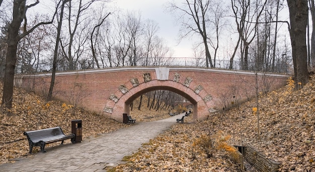 passage à travers un tunnel en brique avec des bancs dans un ancien pont dans un parc de la ville