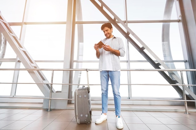 Passager vérifiant le passeport et les billets dans le bâtiment de l'aéroport