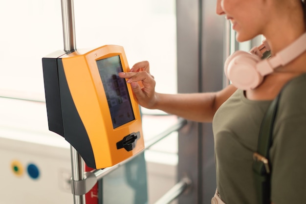 Photo passager woman using ticket machine in modern tram indoor cropped