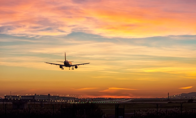 Passagers avion atterrissant à la piste de l'aéroport dans la belle lumière du coucher du soleil