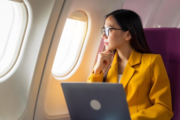 Photo passagers d'avion féminins chinois asiatiques entrepreneurs en vol s'aventurer à l'étranger