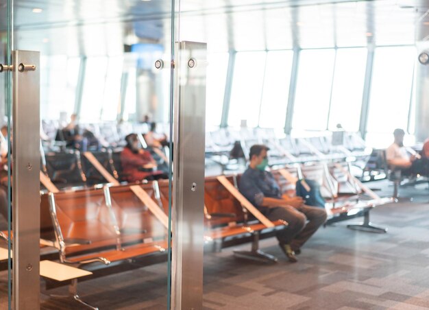 Passagers flous abstraits dans un arrière-plan d'aéroport asiatique. Motion blur bondé de personnes marchant le long du couloir.