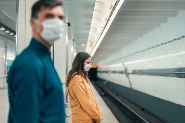 Passagers portant des masques de protection debout à la station de métro. coronavirus en ville