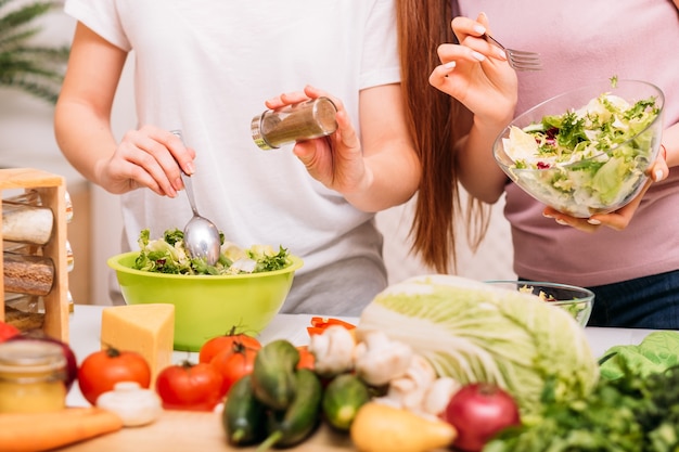 Passe-temps de cuisine. Aliments biologiques. Mode de vie sain. Deux femelles préparant une salade verte.