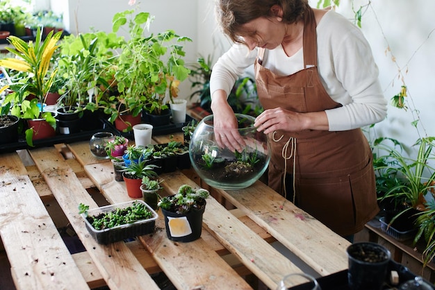 Le passe-temps des femmes. Une fleuriste nerd fait un mini terrarium avec des plantes d'intérieur