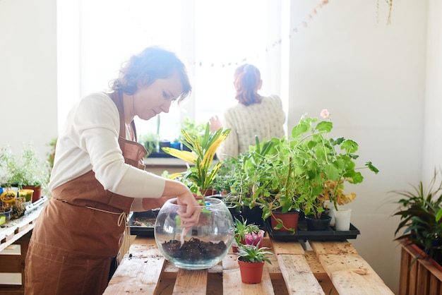 Le passe-temps des femmes. Mère et fille fleuristes botaniques s'occupent des plantes et des fleurs d'intérieur