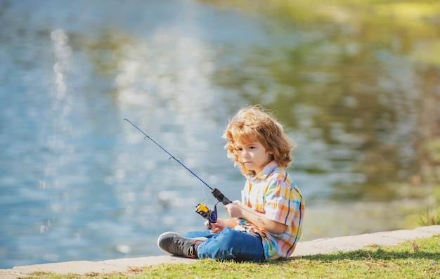 Passe-temps pour les enfants de pêche Garçon avec spinner à la rivière Enfant à la jetée avec tige