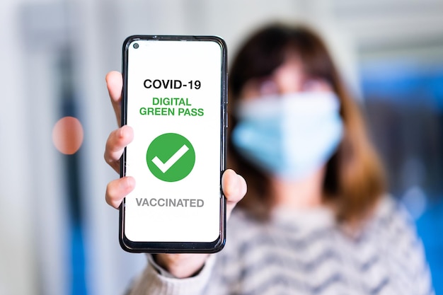 Passe verte du covid-19, une femme montre un téléphone portable avec le passeport sanitaire. Certificat de vaccination pour entrer dans les bars et restaurants ou la vie nocturne, coronavirus