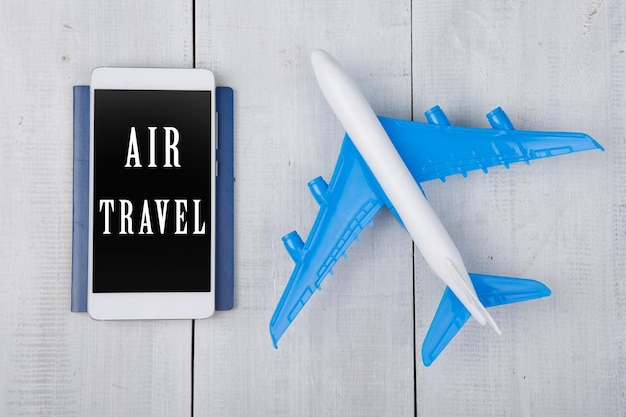 Photo passeport d'avion et smartphone avec texte air travel sur table en bois blanc