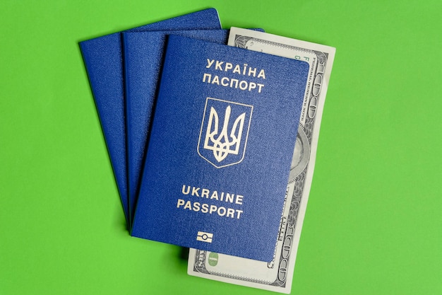 Passeport biométrique ukrainien avec un billet de cent dollars sur fond vert