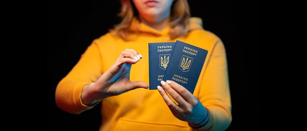 Passeport national ukrainien Belle fille ukrainienne avec passeport gouvernemental dans ses mains sur fond noir