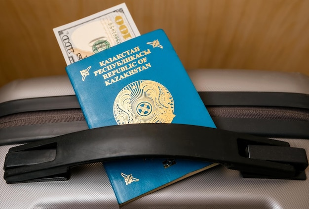 Le passeport de la République du Kazakhstan se trouve sur la valise grise Soft focus Dollar currency