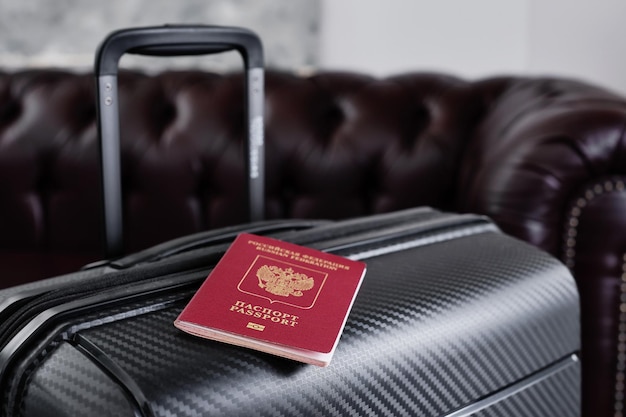 Passeport russe sur une valise de voyage noire mise au point sélective L'émigration des Russes du pays problèmes avec les réfugiés de visas