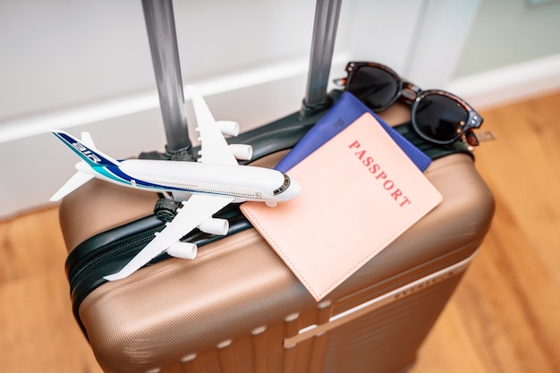 Passeports touristiques, un avion jouet sur une valise de voyage. Photo conceptuelle d'un voyage touristique
