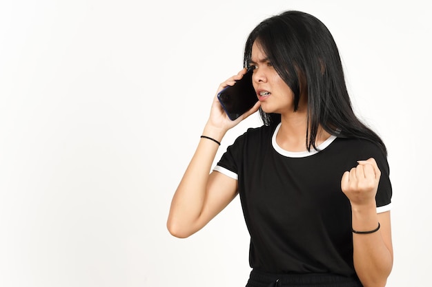 Passer un appel téléphonique à l'aide d'un smartphone avec un visage en colère de belle femme asiatique isolée sur blanc