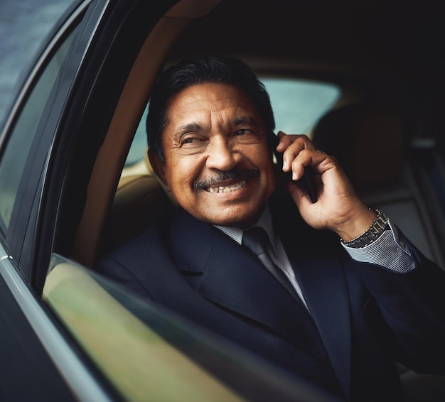 Passer des appels professionnels en déplacement Photo d'un homme d'affaires mature utilisant son téléphone lors d'un voyage en voiture