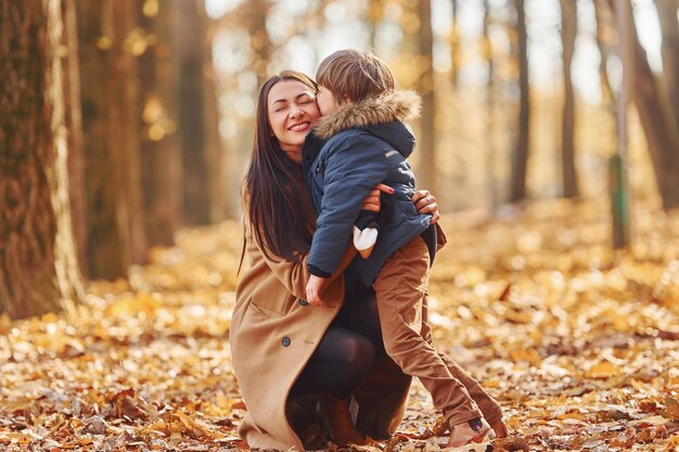 Passer un week-end actif La mère et son fils s'amusent à l'extérieur dans la forêt d'automne