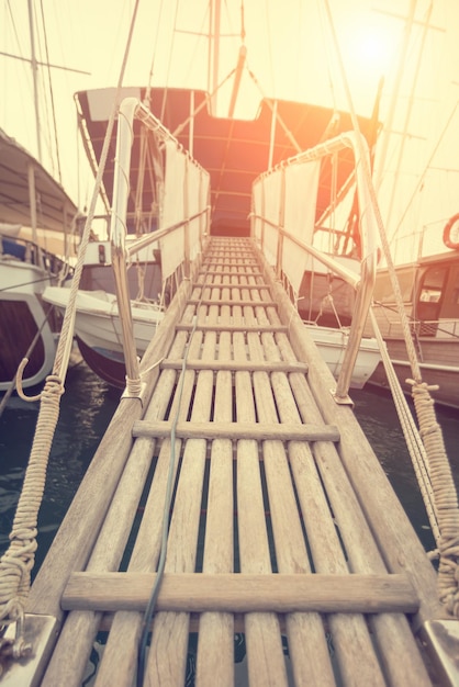 Passerelle en bois sur yacht séjournant au port au coucher du soleil