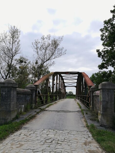 Une passerelle par les arbres contre le ciel