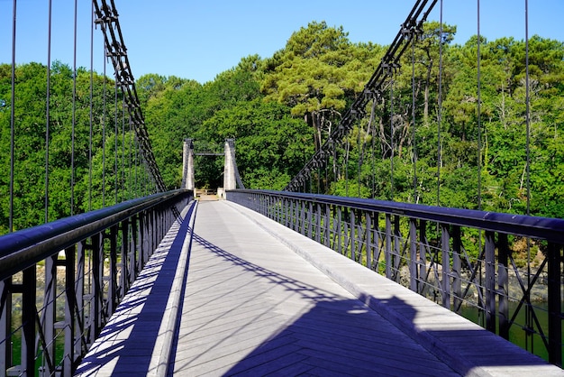 Passerelle traversant un pont vide suspendu au-dessus de la rivière pour les piétons