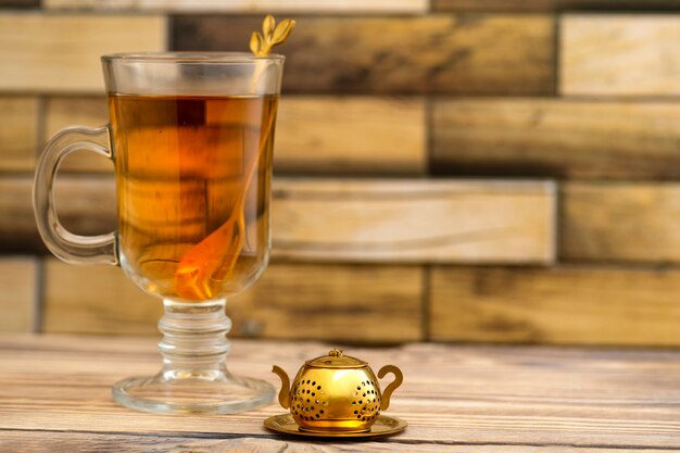 Passoire à thé vintage et un verre de thé sur une table en bois avec place pour le texte