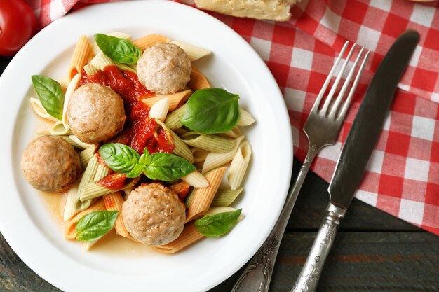 Photo pasta avec boulettes de viande sur assiette sur fond de table en bois